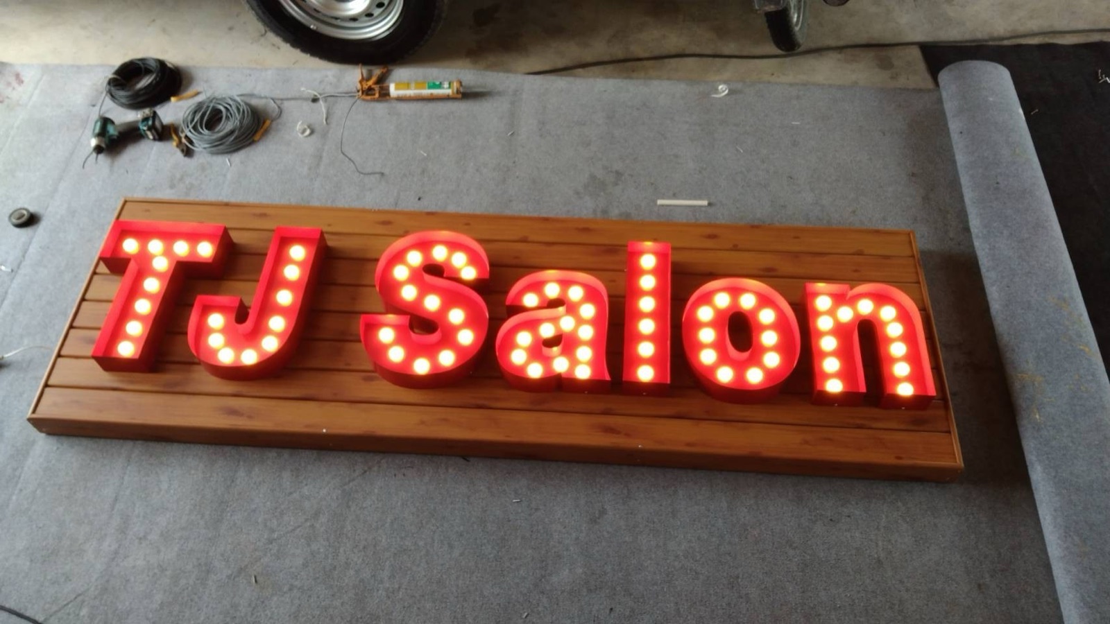 TJ Salon marquee bulb letters on a timber backer in the Mommy Signage workshop